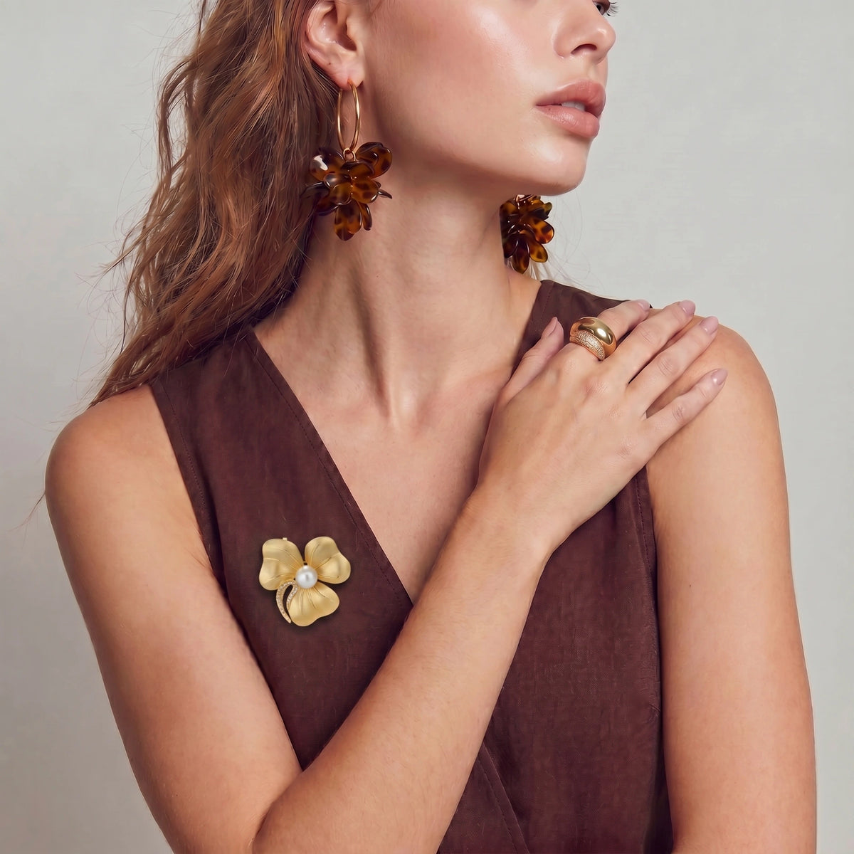 Golden Bloom flower brooch worn on a sleeveless brown top.