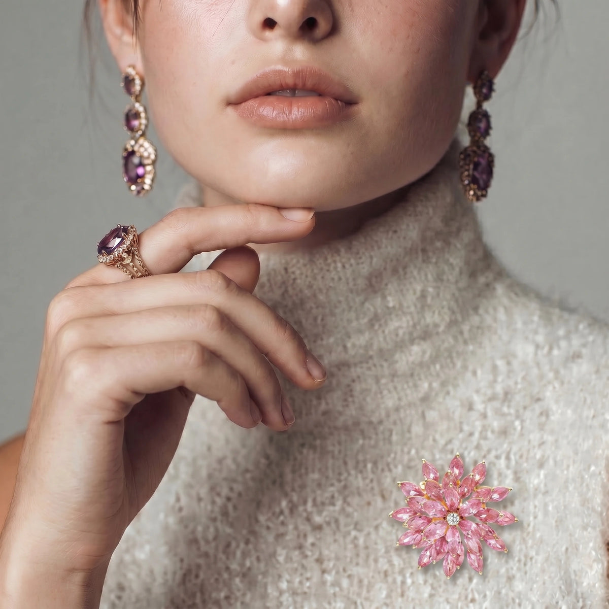 Close-up of the Bloom Burst pink floral brooch worn on a gray knit sweater.