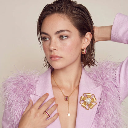 Close-up of the Gold Bloom flower brooch worn on a pale pink top.
